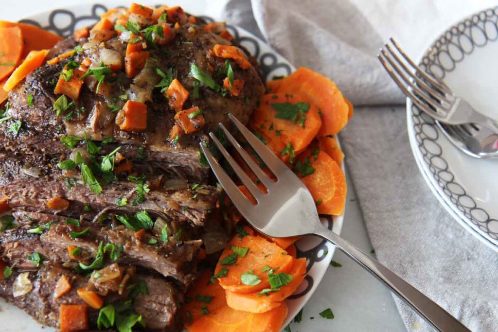 Slow Cooker Brisket Recipe - that is so easy and super comfort food tasty. Grab the meat, carrots, onions, onion soup mix, and all the wine you can pour. Happy #slowcooking. www.ChopHappy.com #dinner #holiday #Christmasrecipe #SundayDinner #Hanukkah