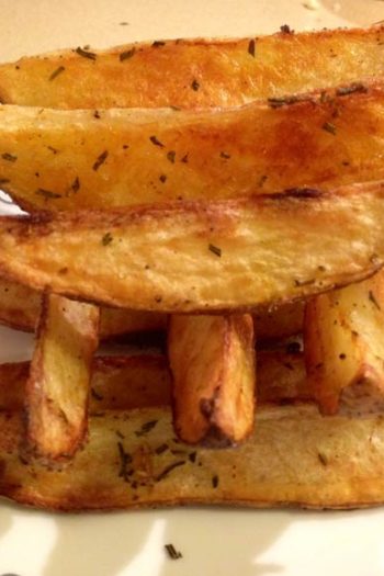 Garlic Rosemary Baked Fries Recipe- are easy oven baked comfort food fun. Grab a couple of potatoes, some rosemary and garlic for a fluffy salty snack. Perfect for weeknights or holiday dinner. www.ChopHappy.comj