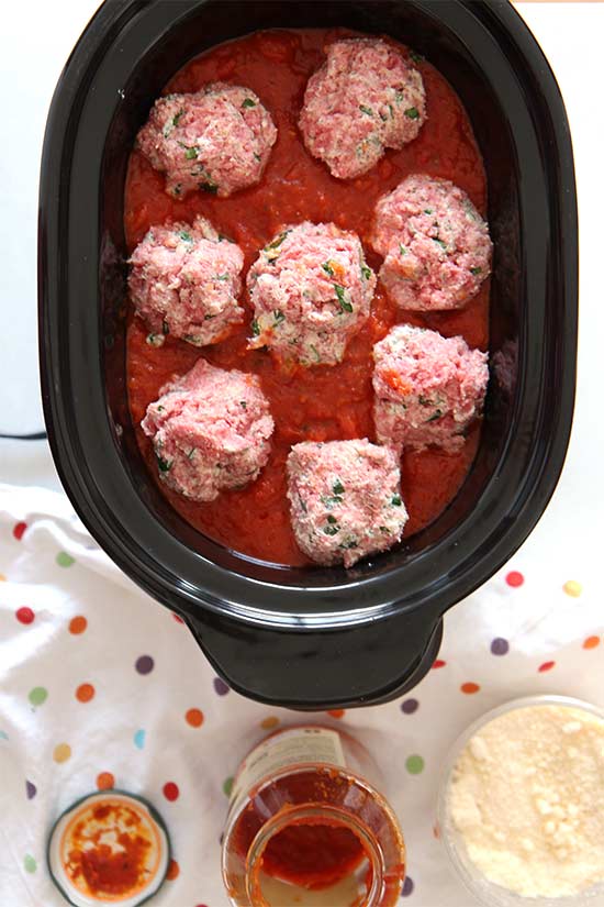 Slow Cooker Meatball Recipe - is the cheesy and easy way to get your family or houseguests to have big smiles every bite. The key is ground beef, spices, fresh herbs (basil, parsley, and oregano, and 2 cheesy ingredients that make the meatballs super soft. Hope you love this recipe. www.ChopHappy.com