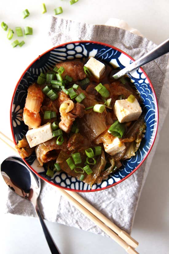 Slow Cooker Kimchi Soup Recipe- is a warm bowl of sweet and spicy comfort food hug. Just drop ingredients in slow cooker and come home to warm dinner. www.ChopHappy.com