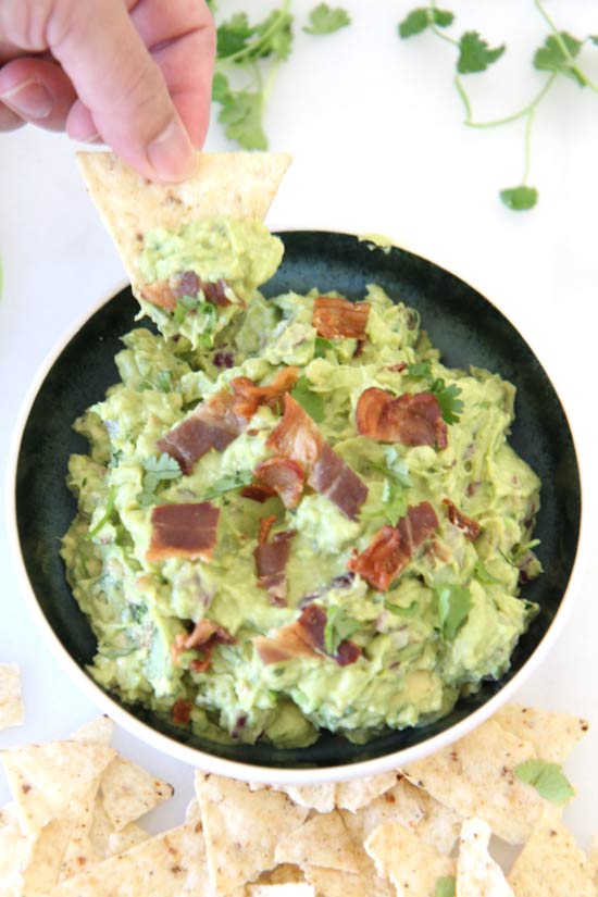 Bacon Guacamole Recipe - that is so creamy delicious you will not stop dipping. Grab avocados, vinegar, onion, and bacon. Happy appetizer making! www.ChopHappy.com