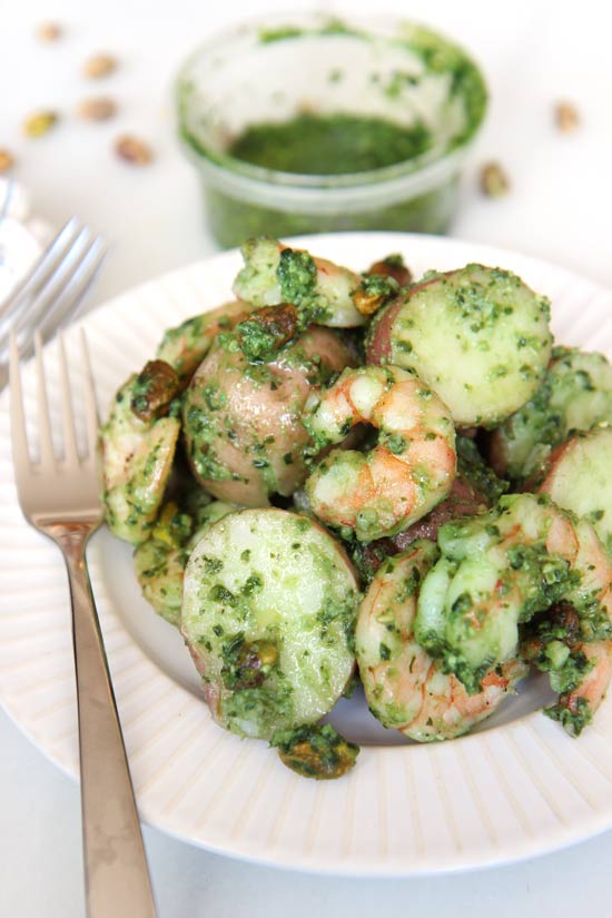 Smiling Shrimp Pesto Potato Salad Recipe that is easy decadent #comfortfood fun. Sweet juicy shrimp mixed with garlic basil pesto makes the perfect summer side dish. Happy Coking! www.ChopHappy.com