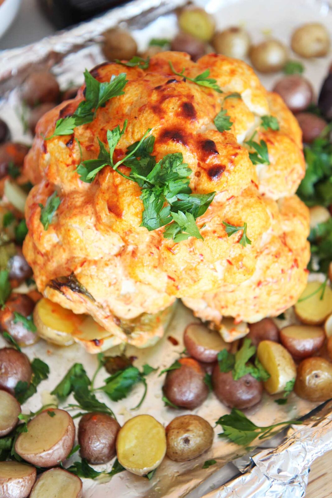 Sheet Pan Whole Roasted Cauliflower and Potatoes Recipe. This is a fast version of a whole roasted cauliflower with a simple trick. Boiling the Cauliflower first makes the center moist and gets speeds up the recipe by 30 minutes. This is the perfect weeknight meal or vegetarian dinner. Happy Cooking! www.Chophappy.com #caulifower #vegetarian