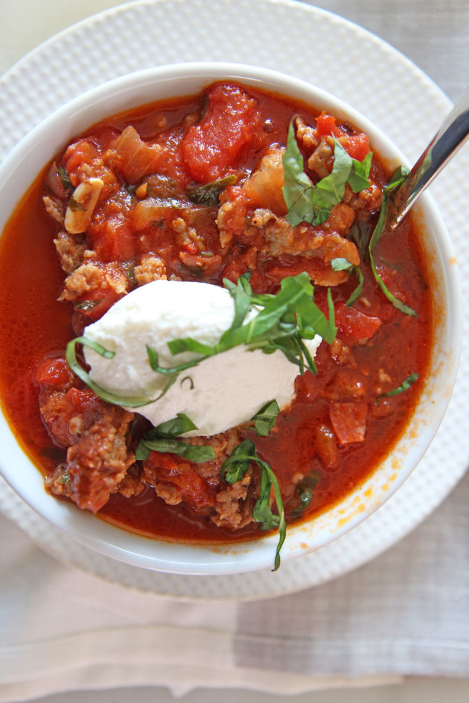 30 Minute Italian Chili Recipe! Grab sweet and spicy Italian sausage and mix with crushed tomatoes, onion, garlic, oregano, red pepper flakes, garlic, basil, parsley, and water. This is the perfect comfort food weeknight dinner recipe. Happy Cooking! www.ChopHappy.com #chilirecipe #Italianrecipe