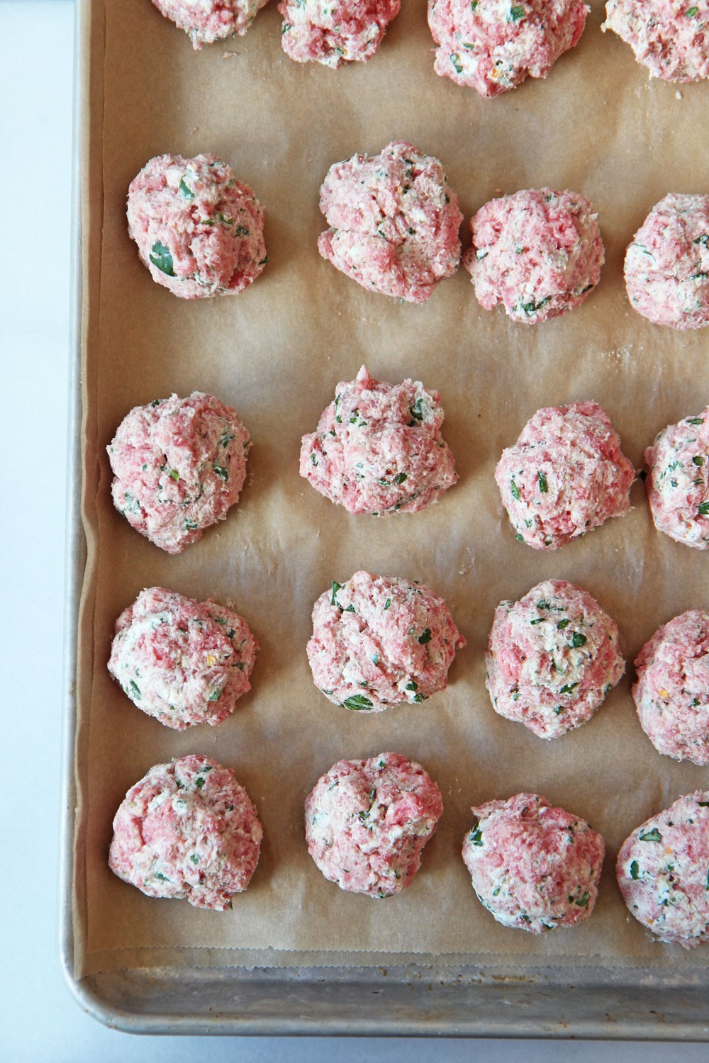 Sheet Pan Cheesy Meatball Recipe. Grab ground beef, ricotta (secret ingredient), parsley, basil, oregano, eggs, breadcrumbs, and marinara. This is an easy no mess weeknight recipe. Happy Cooking! www.ChopHappy.com #sheetpanrecipe #meatballs