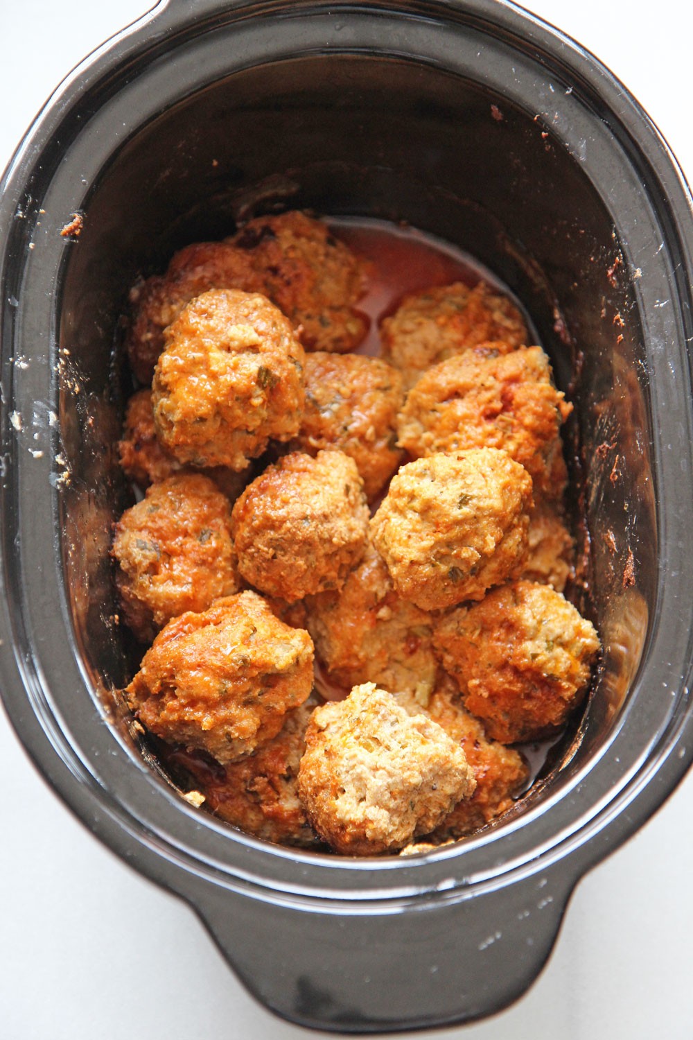 Slow Cooker Buffalo Chicken Meatballs Recipe. Grab chicken, ricotta, celery, eggs, bread crumbs, blue cheese, parsley, and ranch dressing. This is an easy dinner idea for when it is a busy weeknight! Happy cooking! #slowcookerrecipe #chickenmeatballs