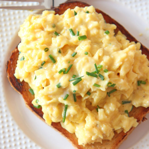 How To Make The Creamiest Scrambled Eggs. This is a perfect simple brunch, breakfast, or dinner that has very little ingredients! Grab eggs, butter, sour cream, and chives. Happy Egg Cooking! www.ChopHappy.com #howtomakescrambledeggs #eggrecipe