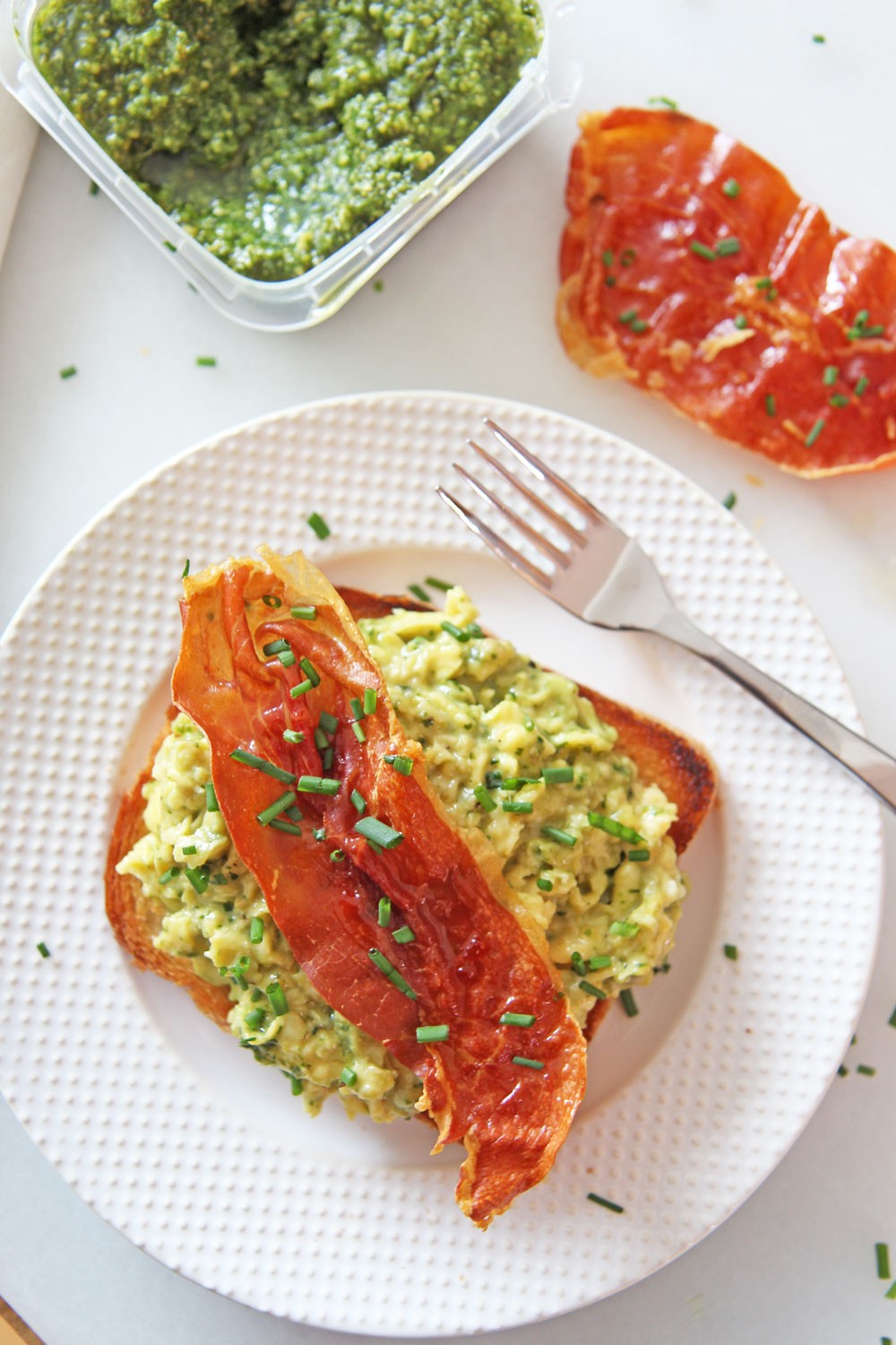 Green Eggs and Ham (Pesto Scrambled Eggs and Crispy Prosciutto) Recipe. Grab pesto, make the creamiest scrambles eggs, and grab a sheet pan for crispy sweet prosciutto. This is a fast treat yourself brunch, breakfast for dinner, or birthday recipe! Happy Cooking! www.ChopHappy.com #scrambled eggs #breakfastrecipe