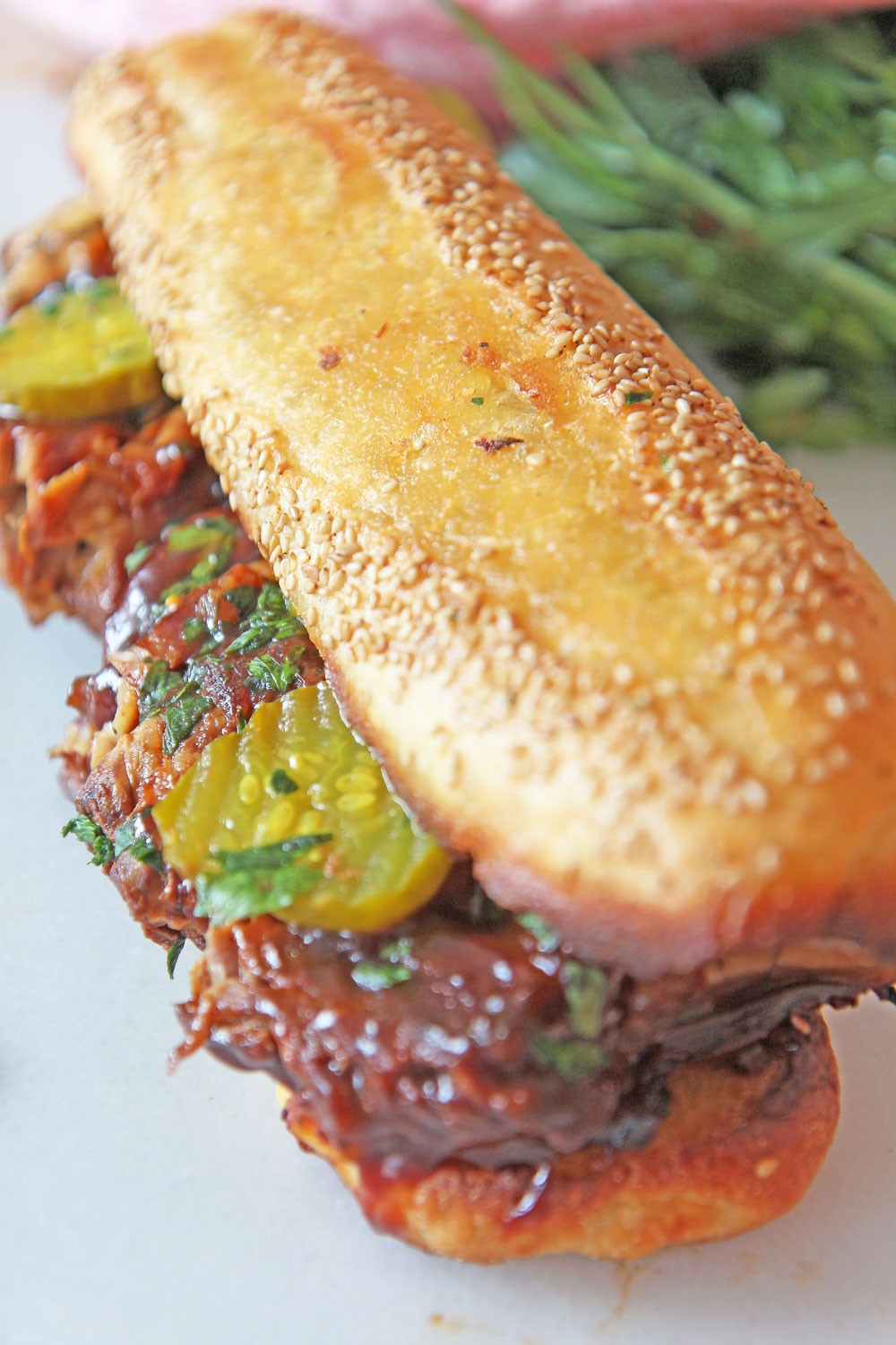 Huge BBQ Pork Sandwich with Garlic Bread Bun (slow cooker recipe). Grab pork ribs, BBQ sauce, pickles, and garlic bread. This is perfect party food, picnic, or summer time eats. Happy Cooking! www.ChopHappy.com #slowcookerecipes #sandwichrecipe