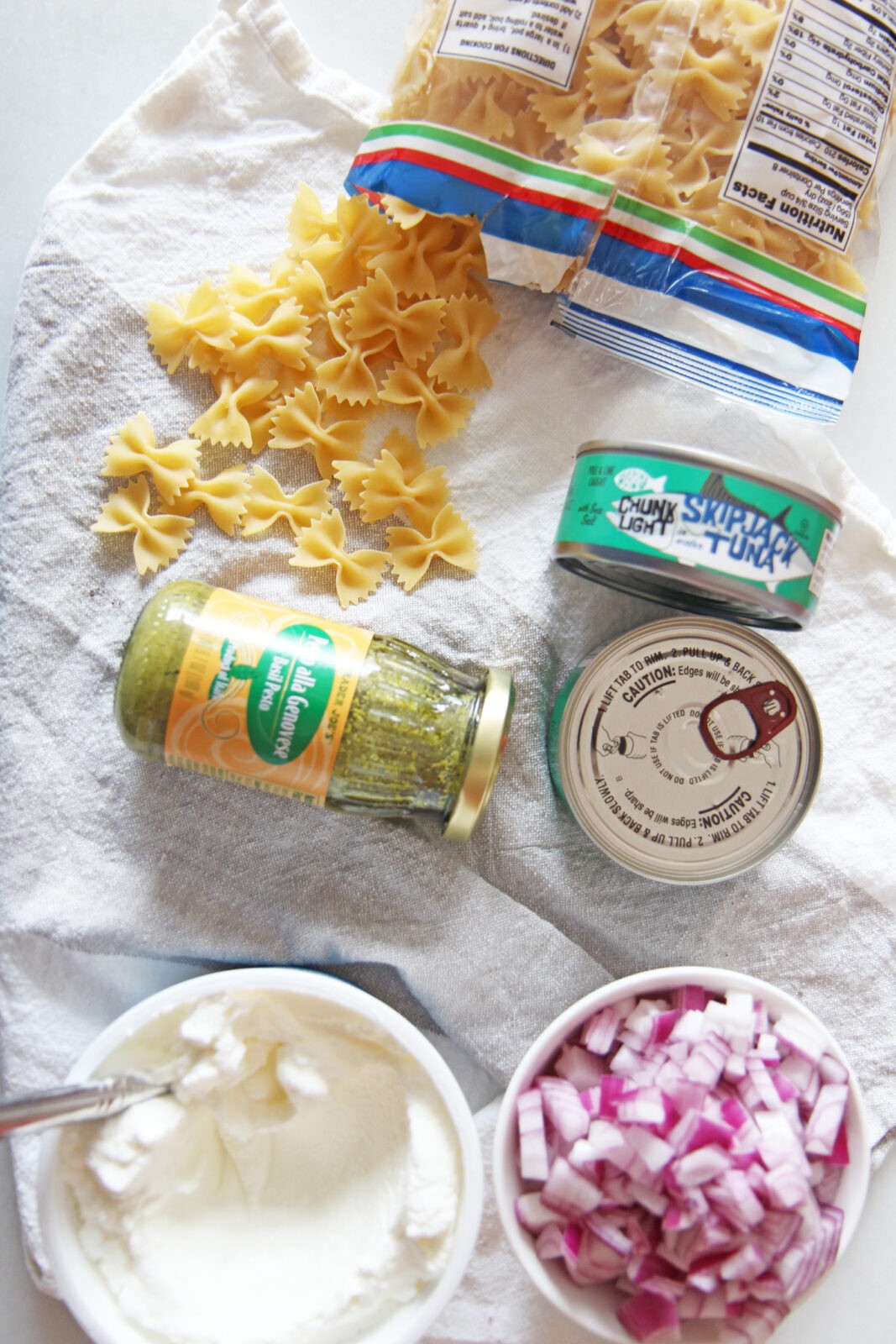 Pesto Tuna Pasta Salad (5 Ingredient Panty Recipe). With only 5 ingredients from your pantry and fridge you can have dinner in 20 minutes. Canned tuna, onions, Greek Yogurt, pasta, and pesto are the ingredients for this recipe. Happy Cooking! #pantryingredients #cannedtuna