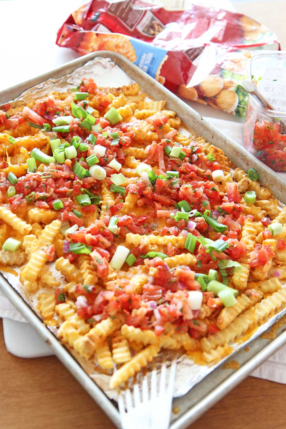 How to Transform Frozen Fries Into Loaded Taco Fries Recipe. Frozen fries, salsa, scallions, cheese, and chili seasoning. Transforming frozen fries is as easy as pantry seasonings cheese, and an oven. Happy sheet pan cooking! www.ChopHappy.com #frozenfries #tacos #pantry