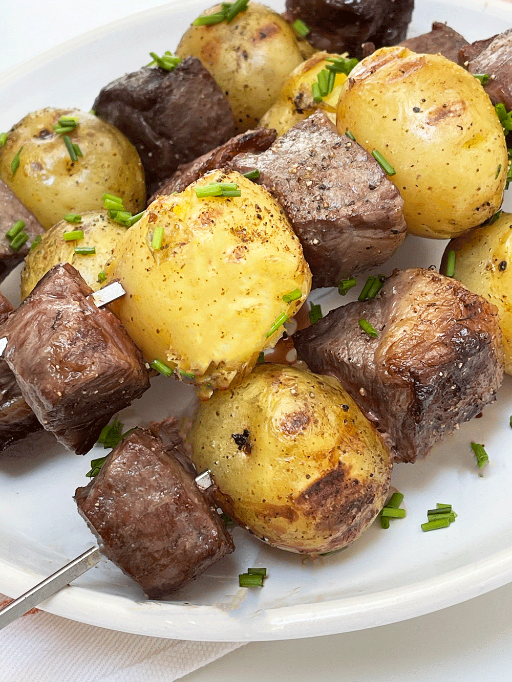 How To Make The Best Grilled Steak and Potato Skewers. This is an easy summer cook out recipe for a bbq. Perfect recipe for a crowd or even just a backyard grilling recipe for your family. Happy Grilling! www.ChopHappy.com #steakskewers #SteakandPotatoes