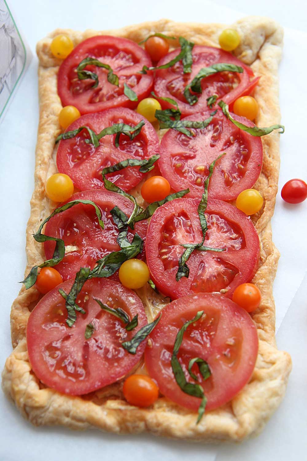 4 Ingredient Puff Pastry Tomato Tart Recipe. This is an easy summer dinner recipe or 4 ingredient appetizer. Happy Cooking! www.ChopHappy.com #tomtorecipes #summerrecipes